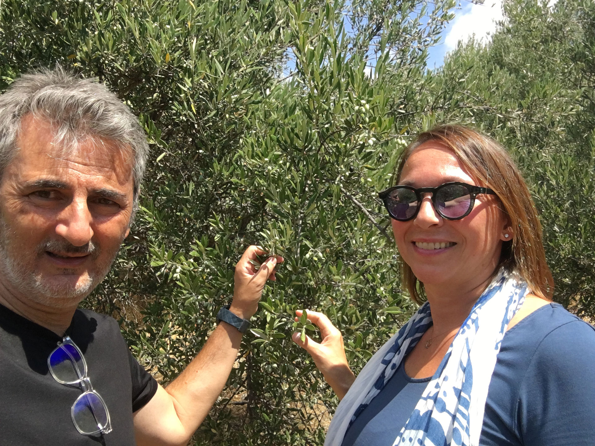 Oblivion Olivenöl. Babis Ioannidis und Karin Zacher vor einem Olivenbaum.